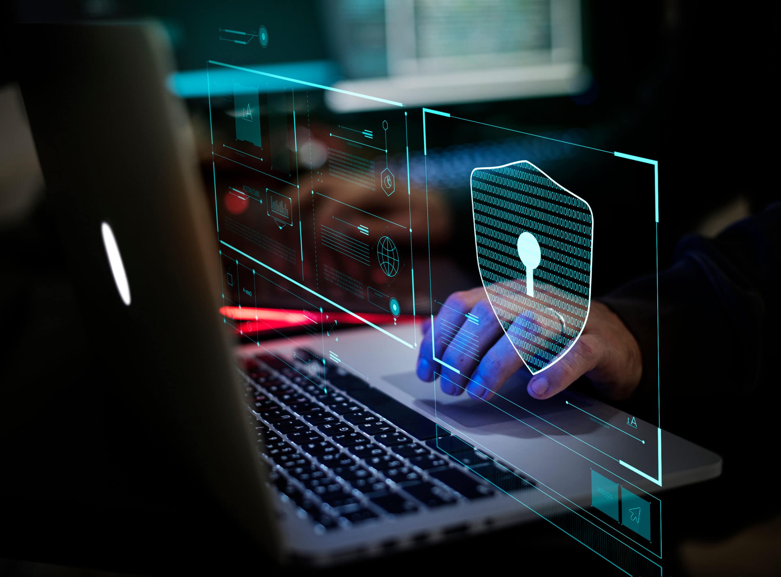 A person uses a laptop with a digital graphic of a security shield and keyhole overlayed on the screen, symbolizing cybersecurity and data protection.