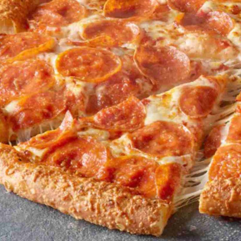 A close-up of a pepperoni pizza with a golden, cheese-stuffed crust. One slice is being pulled away, showing melted cheese stretching from the pizza. The pizza sits on a gray, textured surface.
