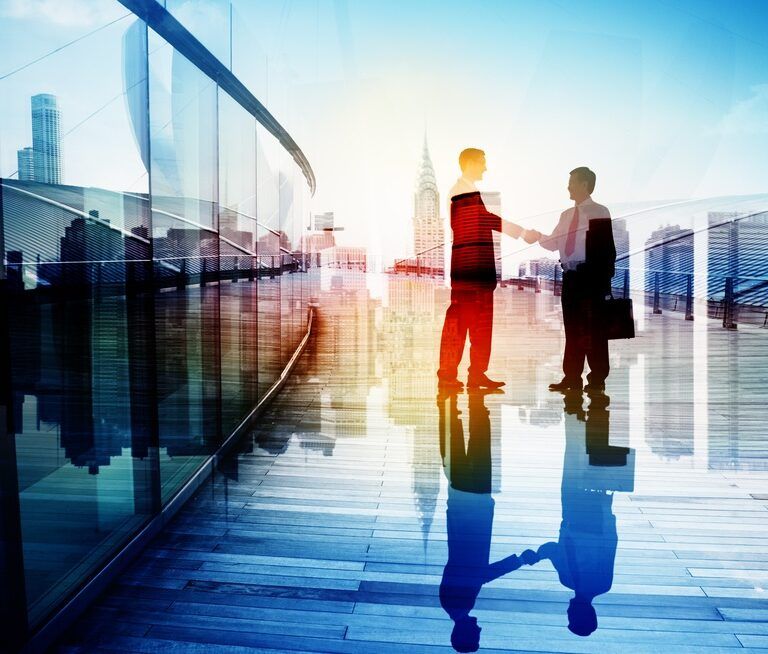 Two businesspeople shake hands on a modern rooftop or terrace with city skyscrapers in the background, sunlight streaming through, and their reflections visible on the shiny floor.