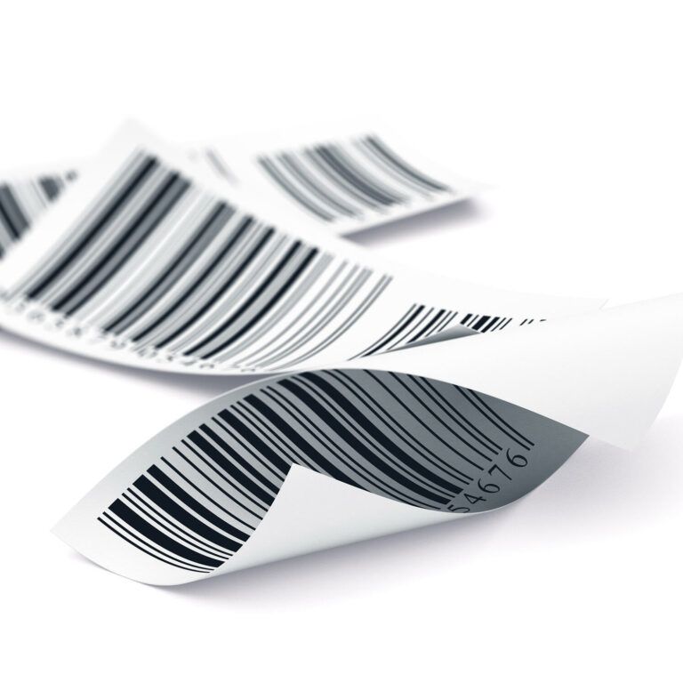 A close-up of several curled paper labels with printed barcodes, lying overlapping on a white background.