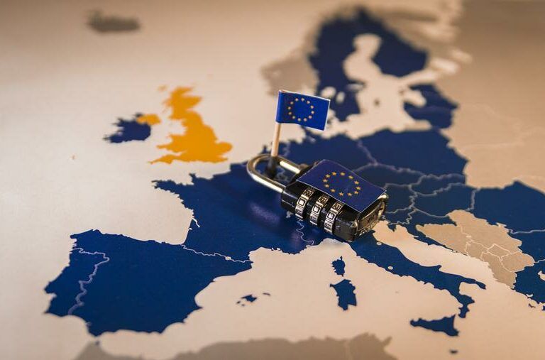 A map of Europe with a padlock and a small European Union flag placed over EU countries; the UK is highlighted in orange, separate from the blue EU countries.