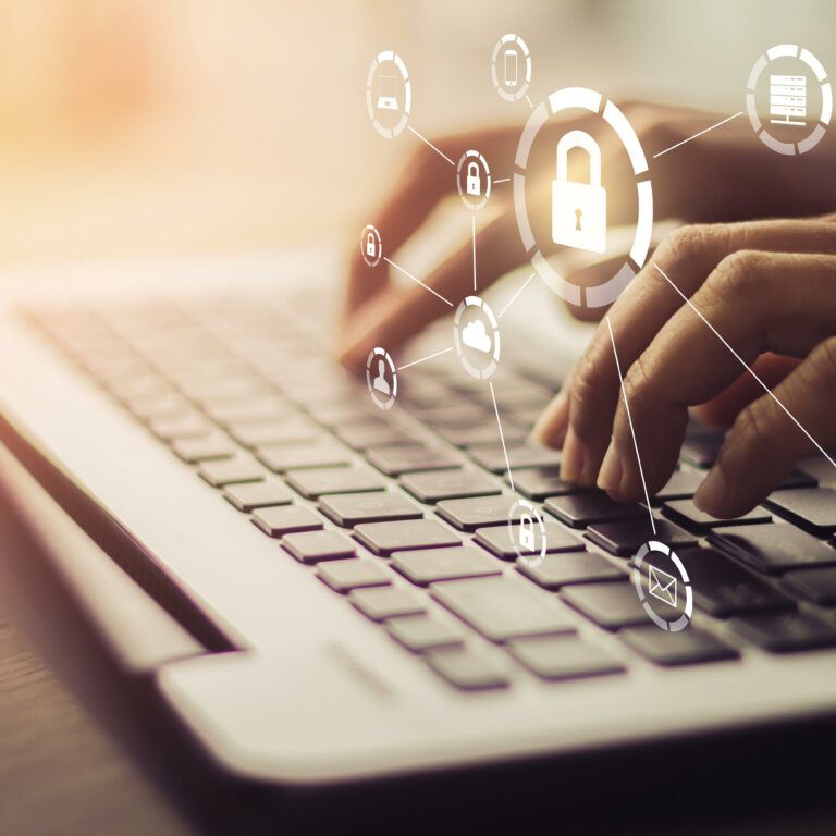 Hands typing on a laptop keyboard with digital security icons and a padlock graphic overlay, representing cybersecurity and data protection.