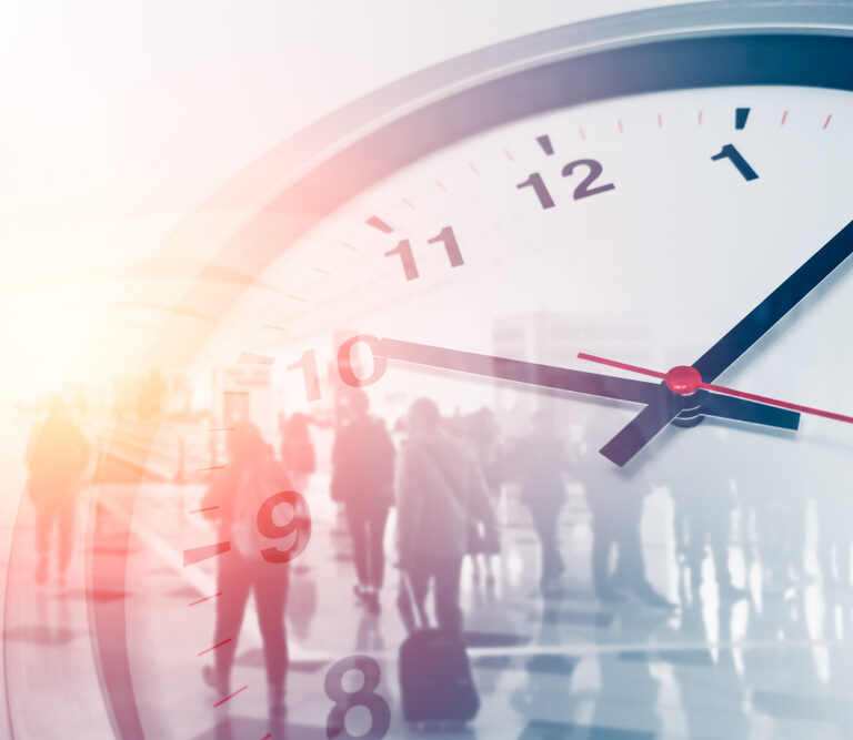 A clock with a blurry image of people walking.