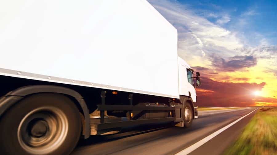 A truck equipped with advanced transportation software is driving on the road.