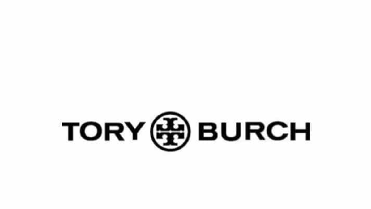 The image shows the Tory Burch logo with bold black text reading TORY BURCH and a decorative circular emblem featuring a symmetrical geometric design between the words. The background is white.