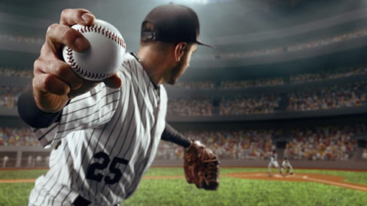A baseball pitcher in a striped uniform, number 25, prepares to throw a pitch in a packed stadium, with blurred players and a cheering crowd in the background.