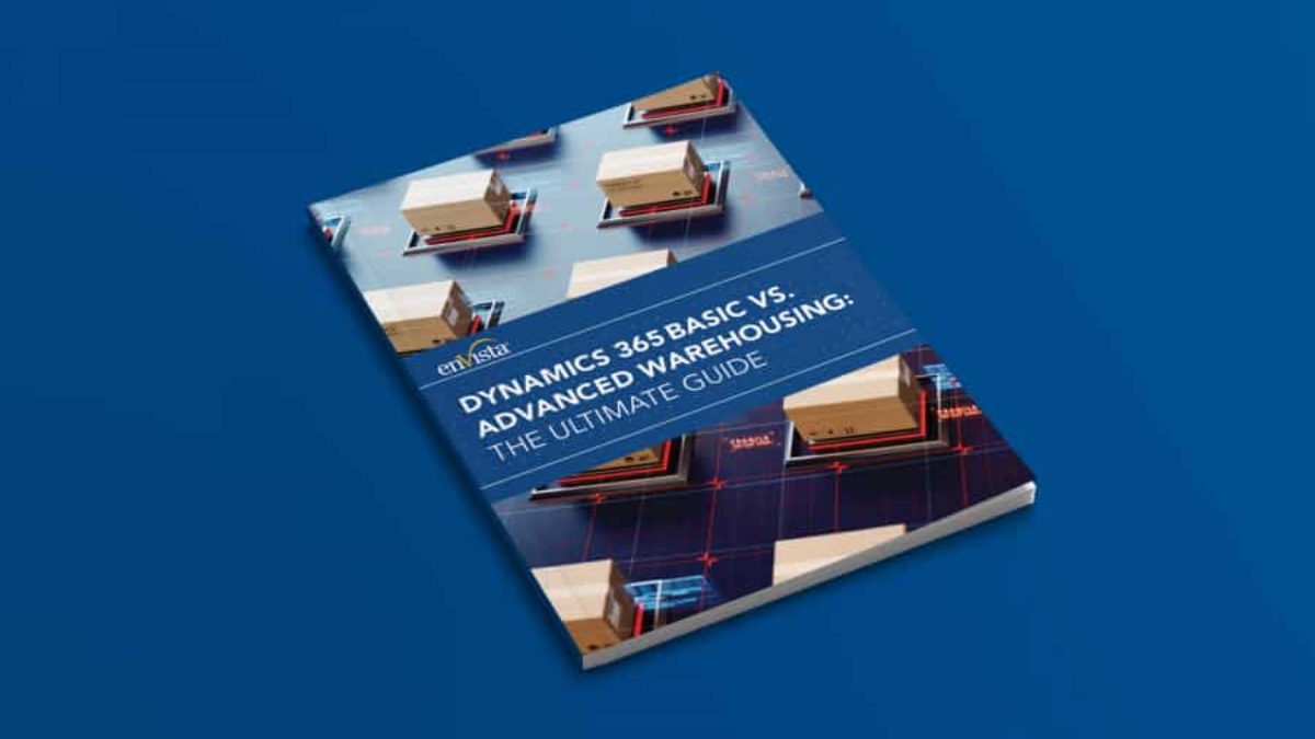 A book titled Dynamics 365 Basic vs. Advanced Warehousing: The Ultimate Guide lies on a blue surface, featuring images of shipping boxes and warehouse graphics on its cover.