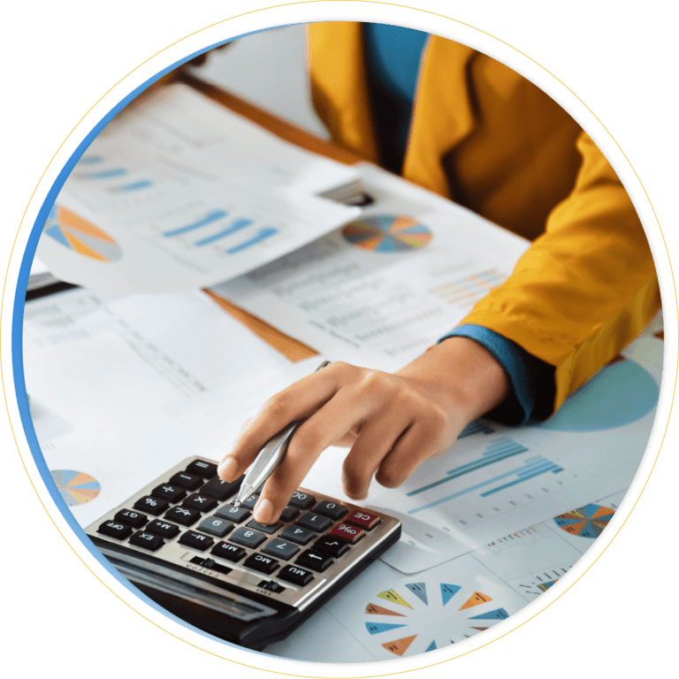 A person in a yellow jacket uses a calculator, surrounded by documents and charts with colorful graphs and pie charts spread out on a desk, analyzing data with the help of Dynamics 365 Finance.