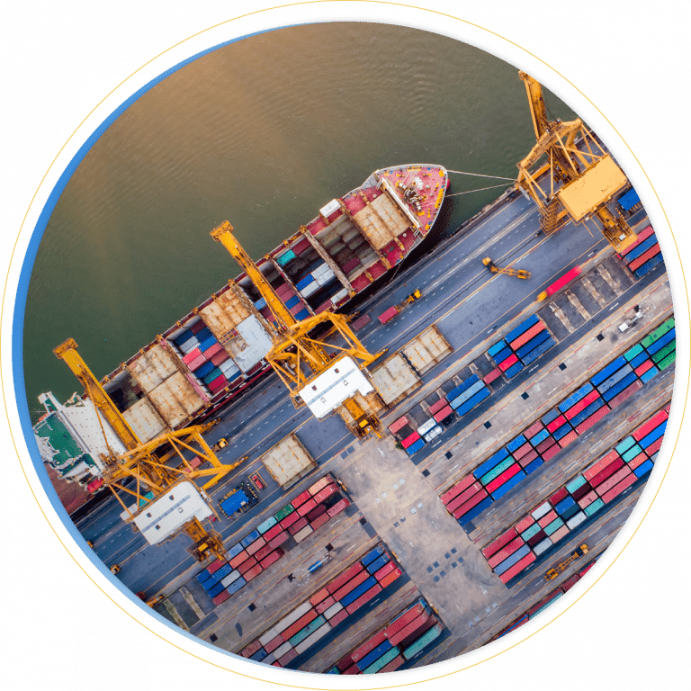 Aerial view of a cargo ship docked at a port with large yellow cranes unloading colorful shipping containers, illustrating the efficiency offered by D365 Supply Chain Management.