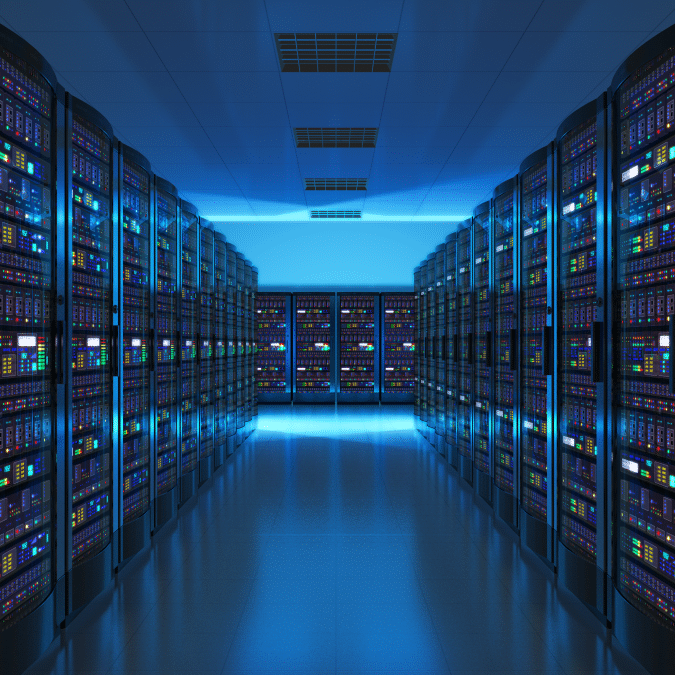 A brightly lit data center with rows of server racks on both sides, filled with colorful blinking lights and a reflective floor, showcases a modern, high-tech atmosphere ideal for cloud managed services.