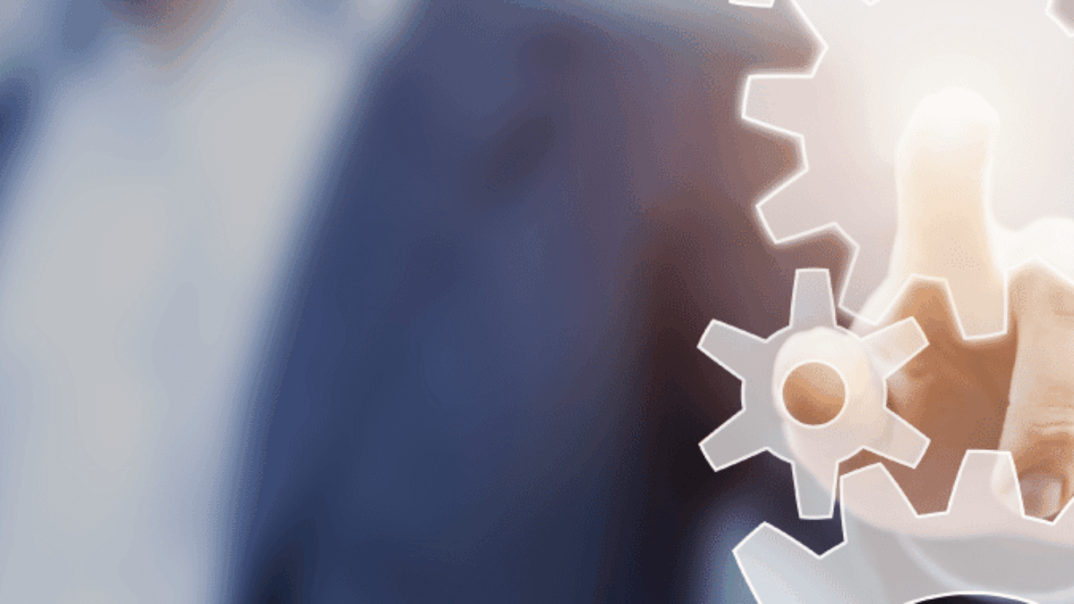A person in a suit touches a glowing gear icon on a transparent screen, symbolizing technology, innovation, or process management.