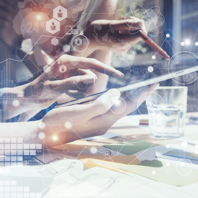 Two people use digital tablets at a desk with documents and a glass of water. Abstract technology and data icons overlay the image, symbolizing innovation, teamwork, and digital collaboration in a modern workspace.