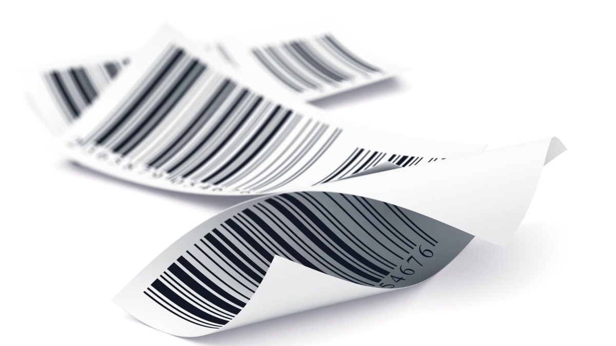 Three curled, white paper receipts with black barcodes are lying on a white surface, overlapping slightly.