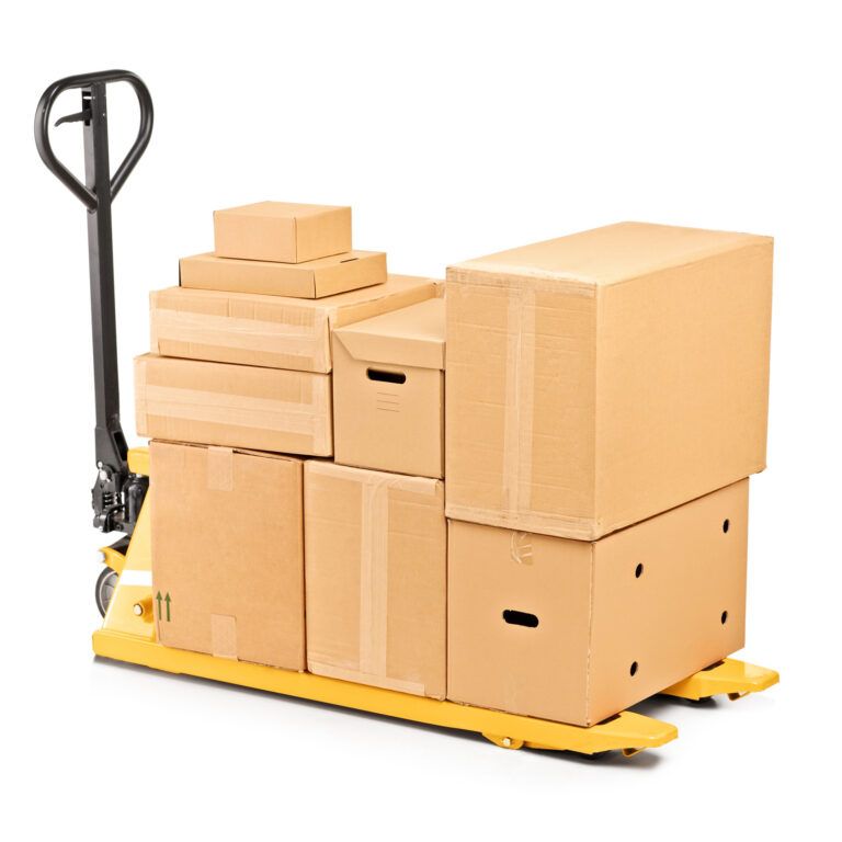 A yellow pallet jack loaded with several stacked cardboard boxes of various sizes, isolated on a white background—ideal for illustrating Lean Process Improvements in warehouse operations.