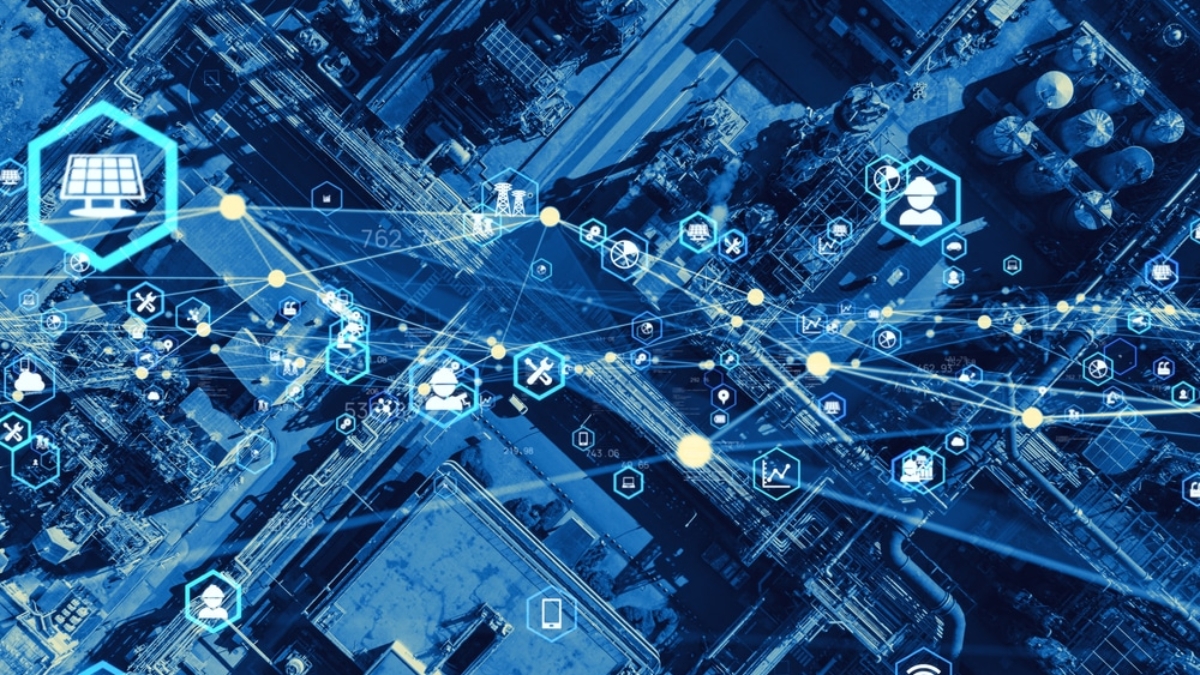 Aerial view of an industrial facility overlaid with digital icons and network lines, symbolizing data connectivity, supply chain optimization, smart technology, and industrial automation. The color scheme is predominantly blue.
