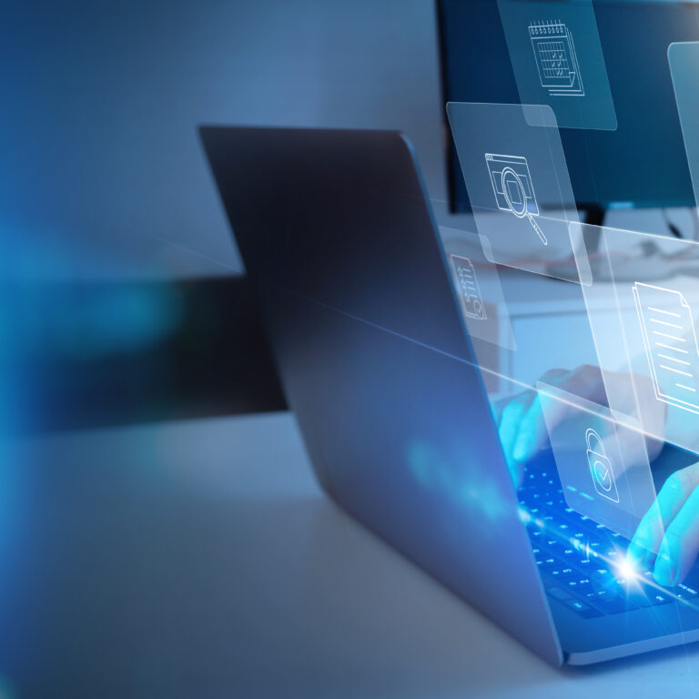 A person types on a laptop with digital icons for cloud storage, folders, and data projected in the air, representing technology and digital file management.