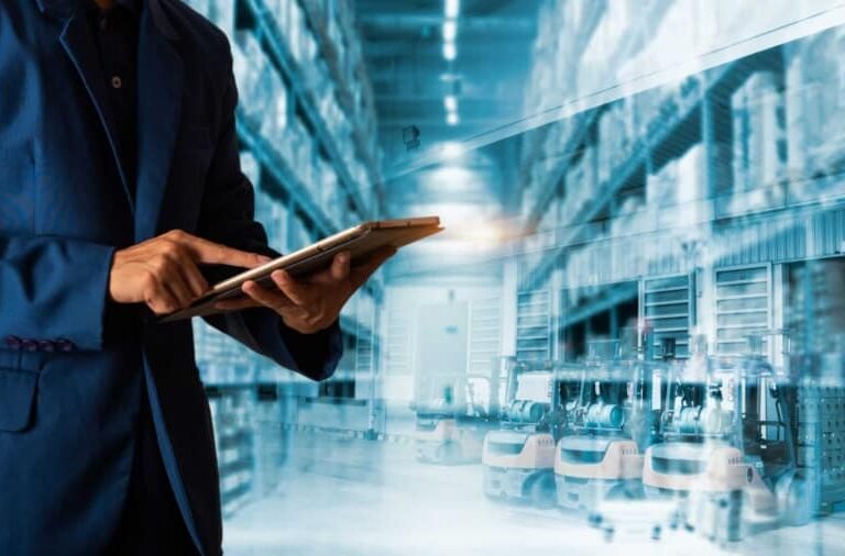 A person in a suit uses a digital tablet in a warehouse with shelves stocked with goods and automated robots operating in the background. The image blends elements of technology and logistics.