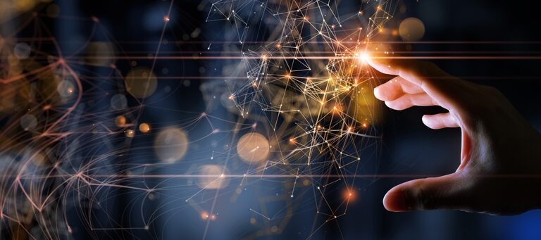 A hand reaches toward glowing, interconnected digital nodes and lines, symbolizing innovation, technology, and networking—echoing what is Microsoft Dynamics 365—against a dark, blurred background with orange light effects.