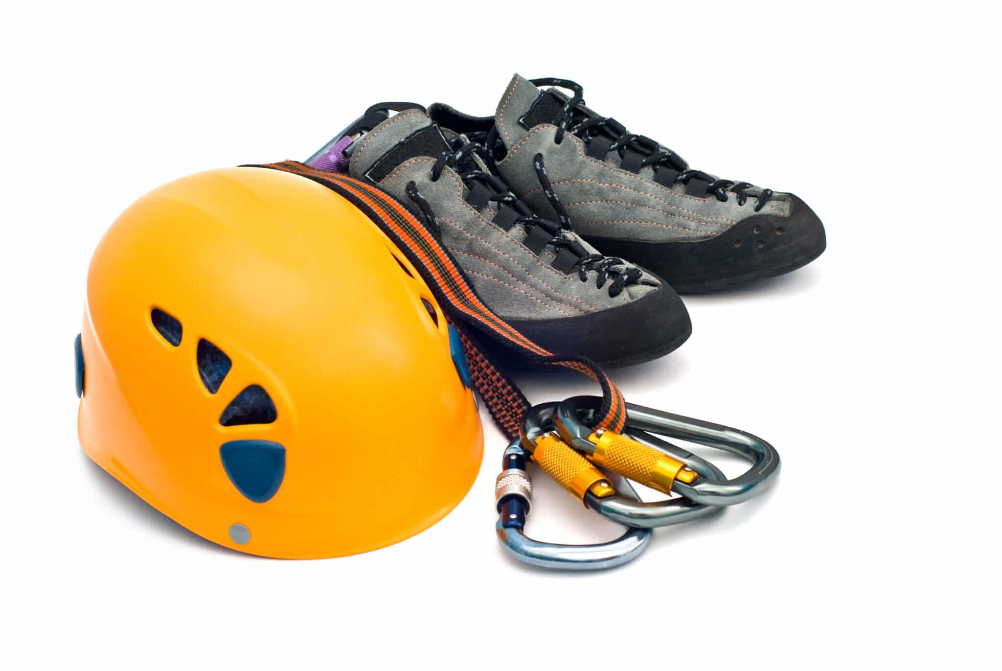 A yellow climbing helmet, gray climbing shoes, a climbing rope, and two locking carabiners are neatly arranged on a white background—ready for your next adventure with Körber WMS reliability in mind.