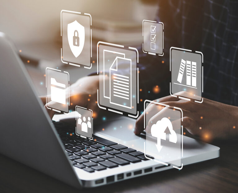 Person typing on a laptop with digital icons for security, documents, cloud storage, folders, and checklists floating above the keyboard, representing Microsoft application management and cybersecurity in digital data environments.