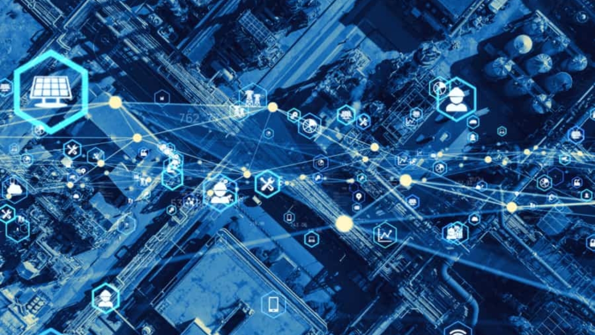 Aerial view of an industrial complex overlaid with digital icons and blue lines representing data connections, illustrating smart technology, the Internet of Things (IoT), and Manufacturing and Operations Strategy Analysis by enVista.