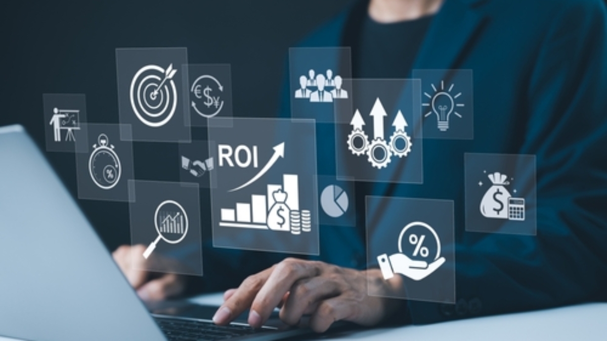 A person in a suit types on a laptop with floating business icons, including graphs, gears, a target, and ROI, symbolizing how a Transportation Management System drives business strategy and financial success.