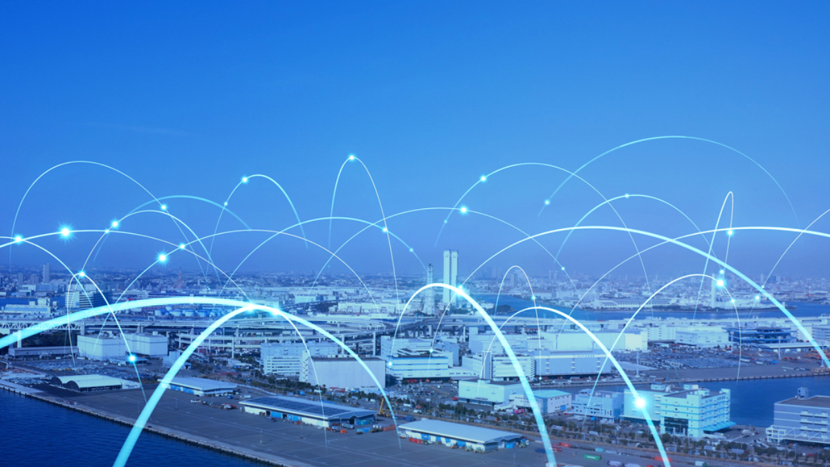 A city skyline and port with digital blue arcs overlaying the image, symbolizing data connectivity and communication networks that drive retail growth and shape what is supply chain strategy across the urban landscape.