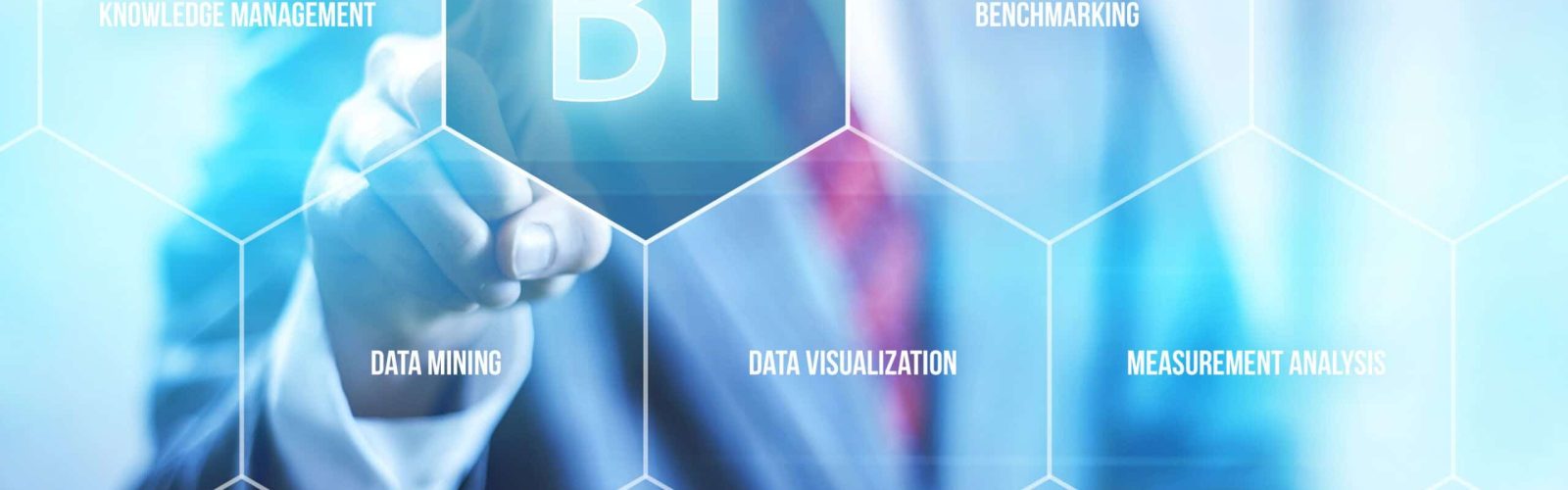 A person in a suit touches a transparent screen displaying hexagons labeled with business intelligence terms like “BI,” “data mining,” “reporting,” and “data visualization.” The background is blurred and professional.