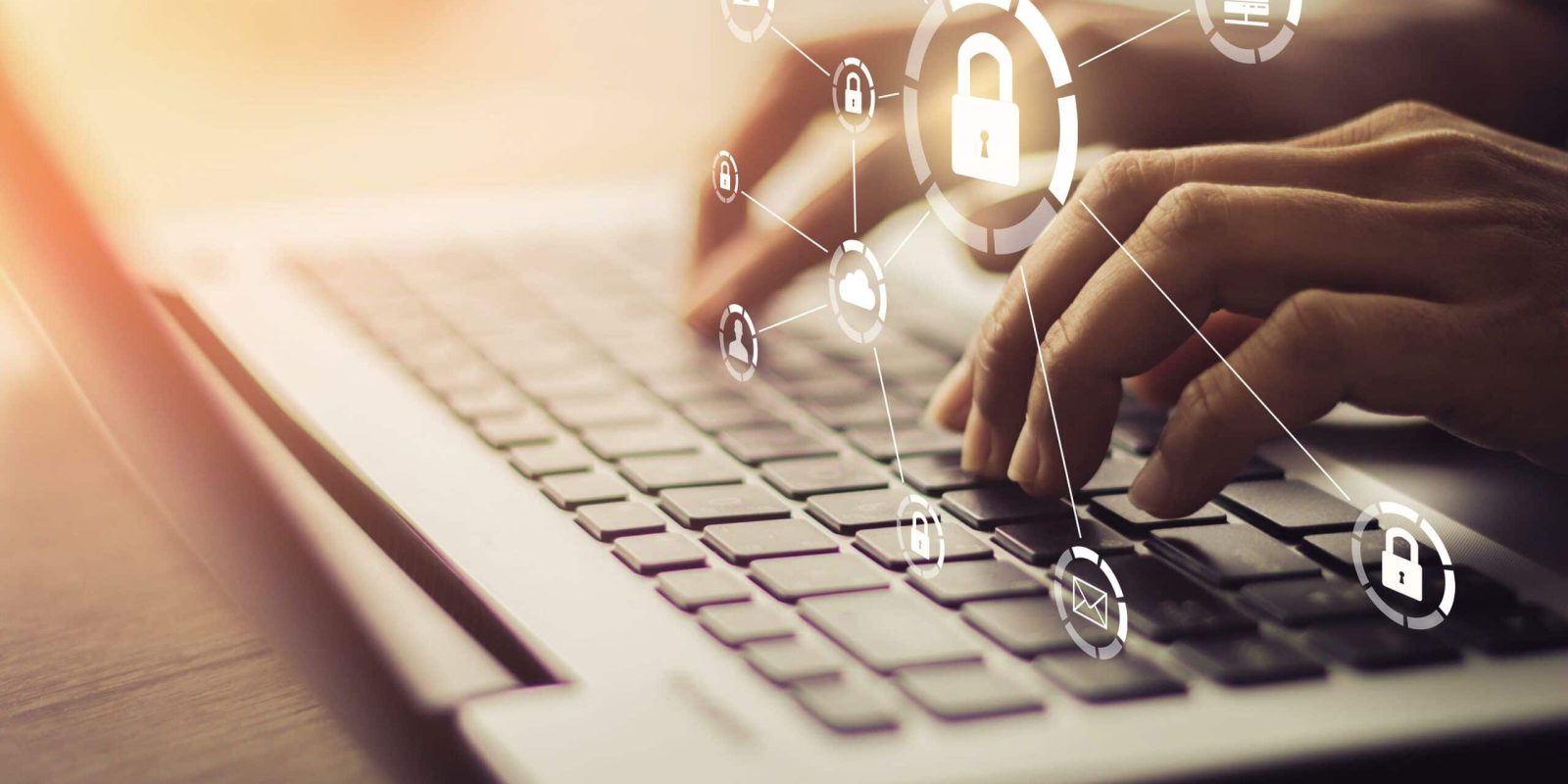 Hands typing on a laptop keyboard with security and technology icons, including a padlock and network symbols, digitally overlaid to represent cybersecurity and data protection.